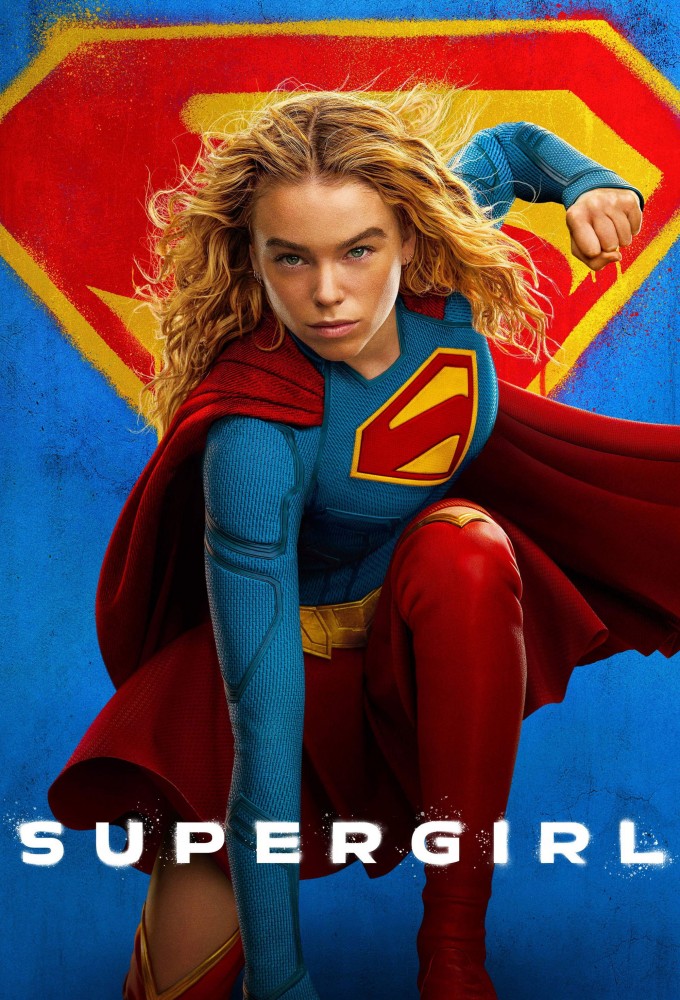 Supergirl in a blue suit with a red cape, crouched in an action pose before a large emblem.